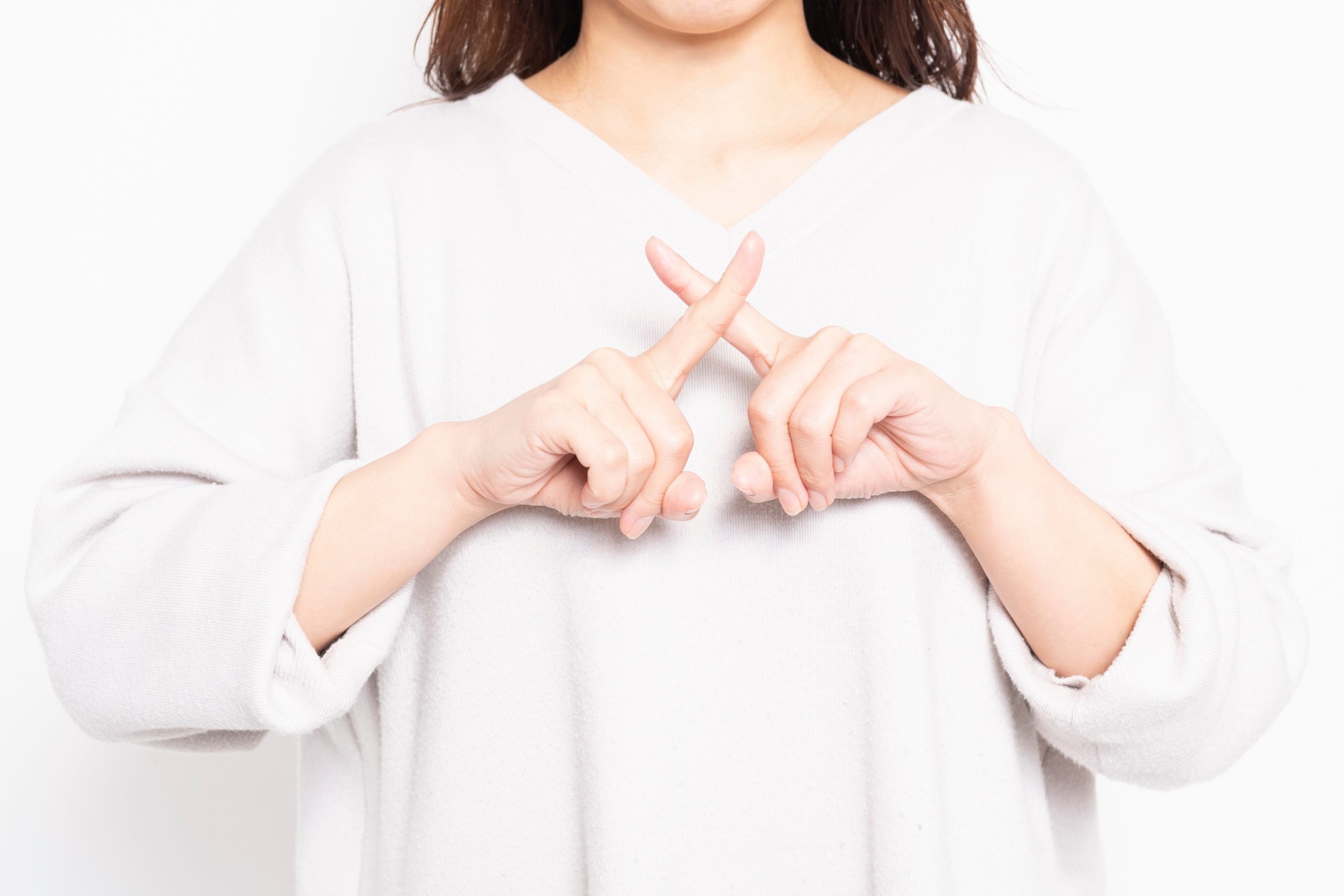 NGのサインを作る若い女性